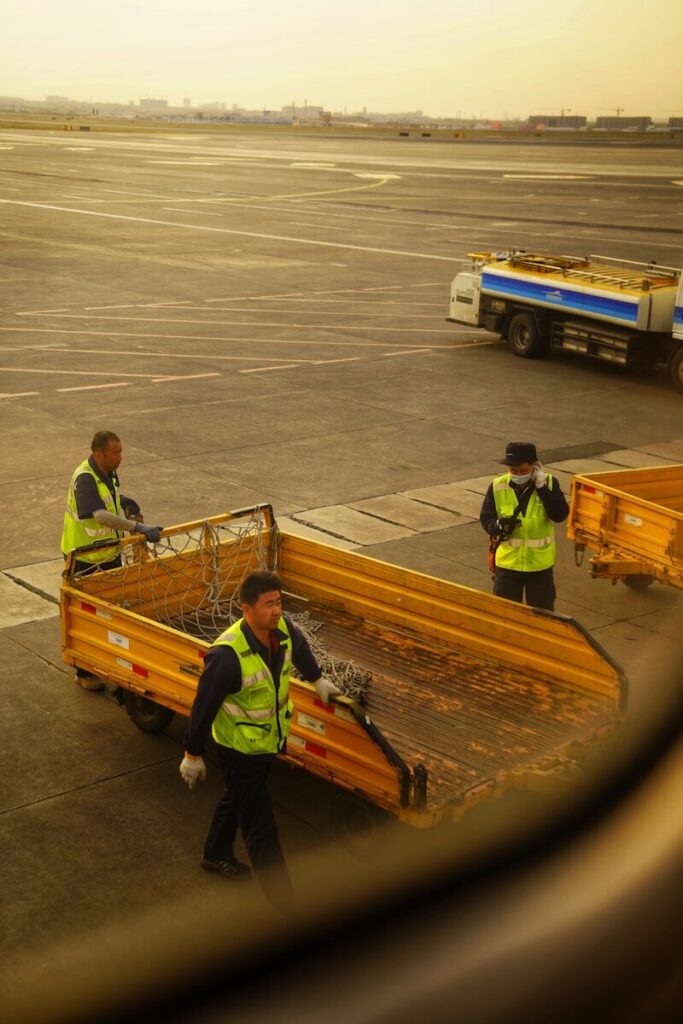 A group of men standing on top of an airport tarmac